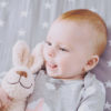 happy-smiling-baby-girl-with-her-toy-on-the-bed-PZ6H8EU-scaled-100x100